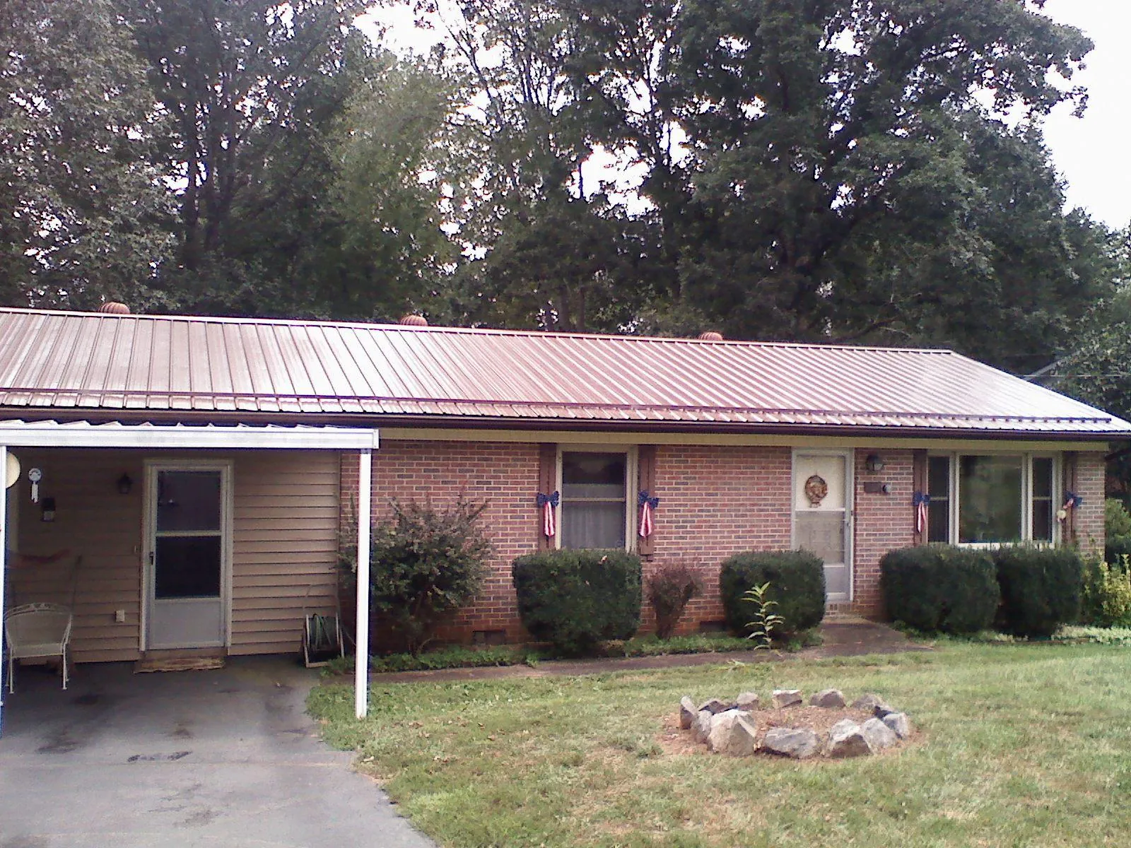 Bronze metal roof and carport on a brick ranch home — Roof Repair work by our crew in Murray